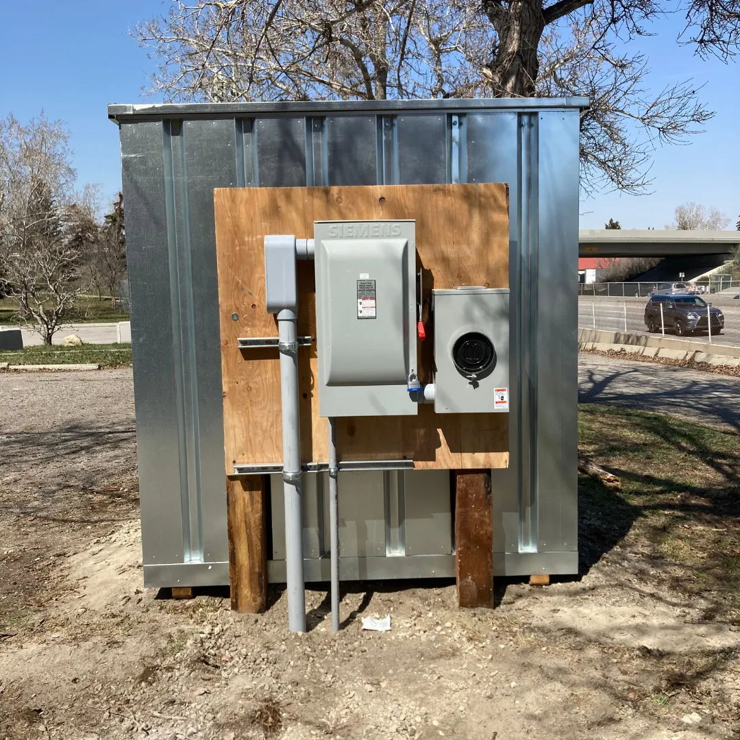 Temporary power hut with service mast on a construction site